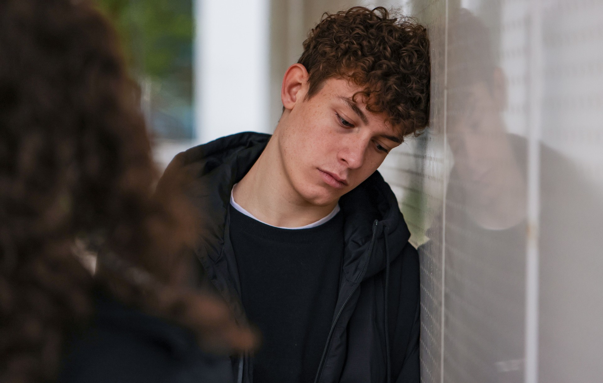 Teenager looking down while sharing problems with his girlfriend